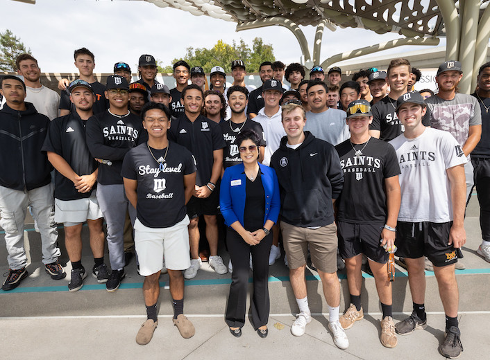 President Seher Awan posing with the men's baseball team.