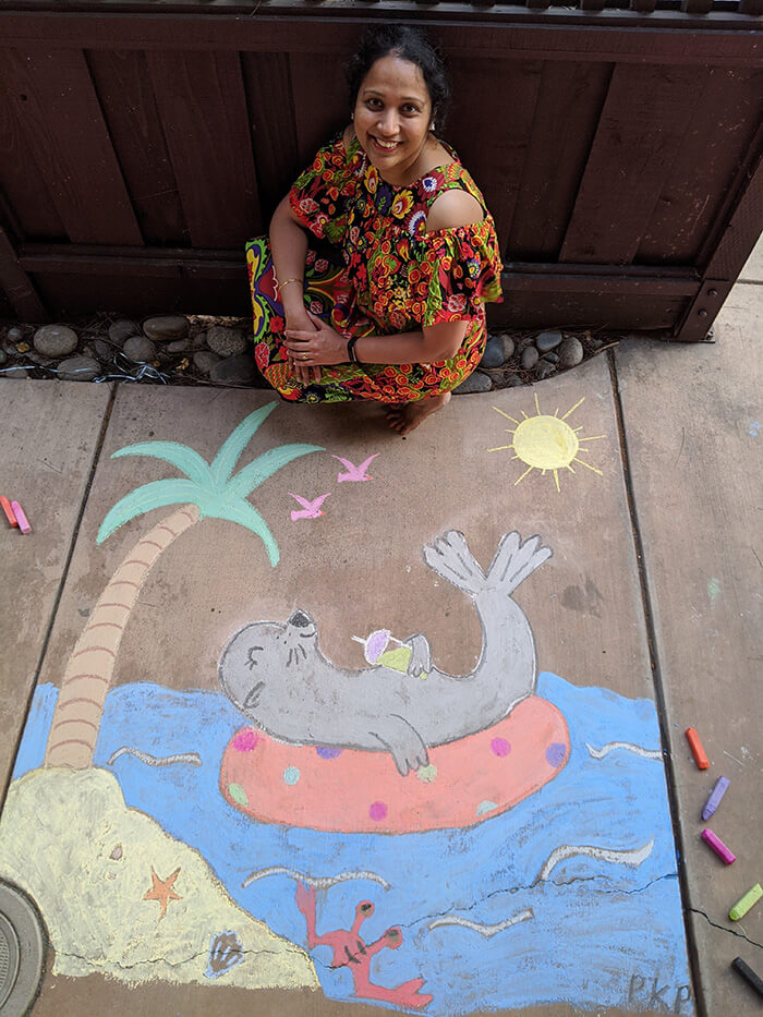 woman in front of chalk drawing of seal on inner tube