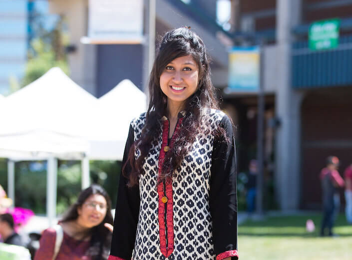Young woman with long dark hair wears traditional East-Indian style clothing in the Central Plaza.