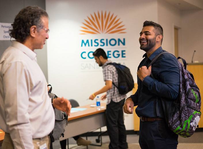 Steve Lipman converses with Raj, a male college student of South Asian descent at Nervous Novice competition. 