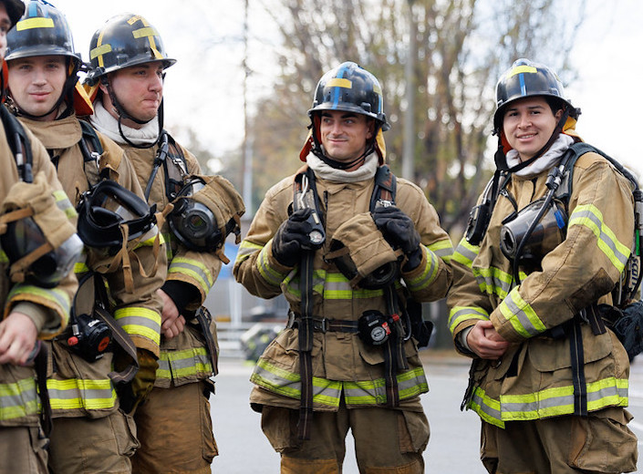 Fire Tech students. Four students stand together in their uniforms.