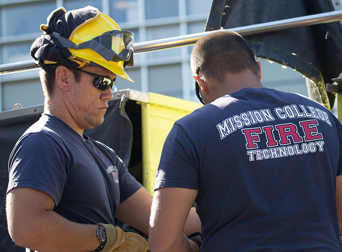 Fire Protection Technology Degree. A male Fire Fighter from behind in his gear during training on campus at Mission College.