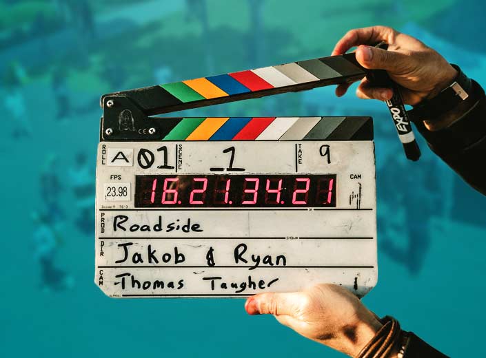 Action board on a film set against a teal background.