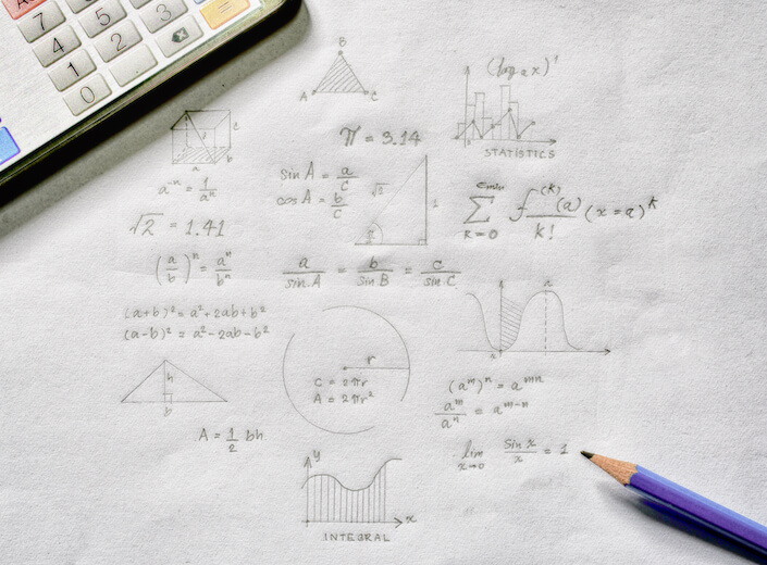 Math equations being worked on using scratch paper. A calculator is visible in the left-hand corner.