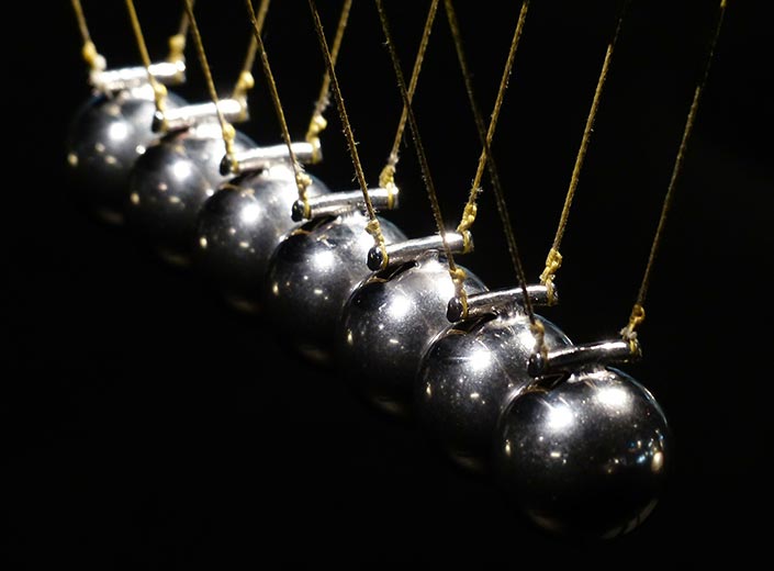 Newton's Cradle - metallic balls suspended on cords demonstrate Physics concept.
