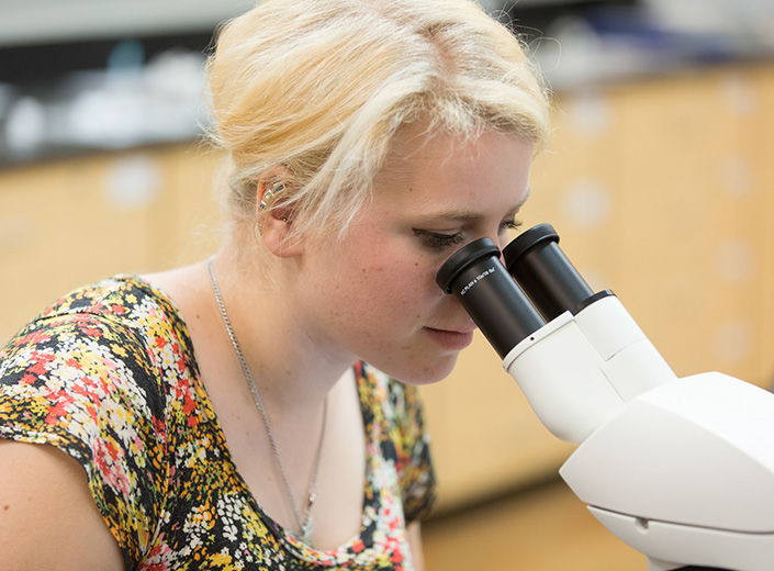 student looking in a microscope