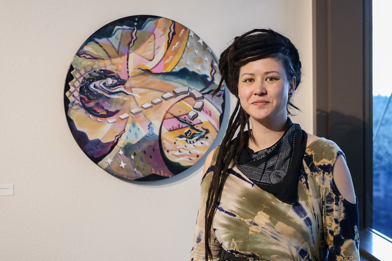 Student standing in front of her art