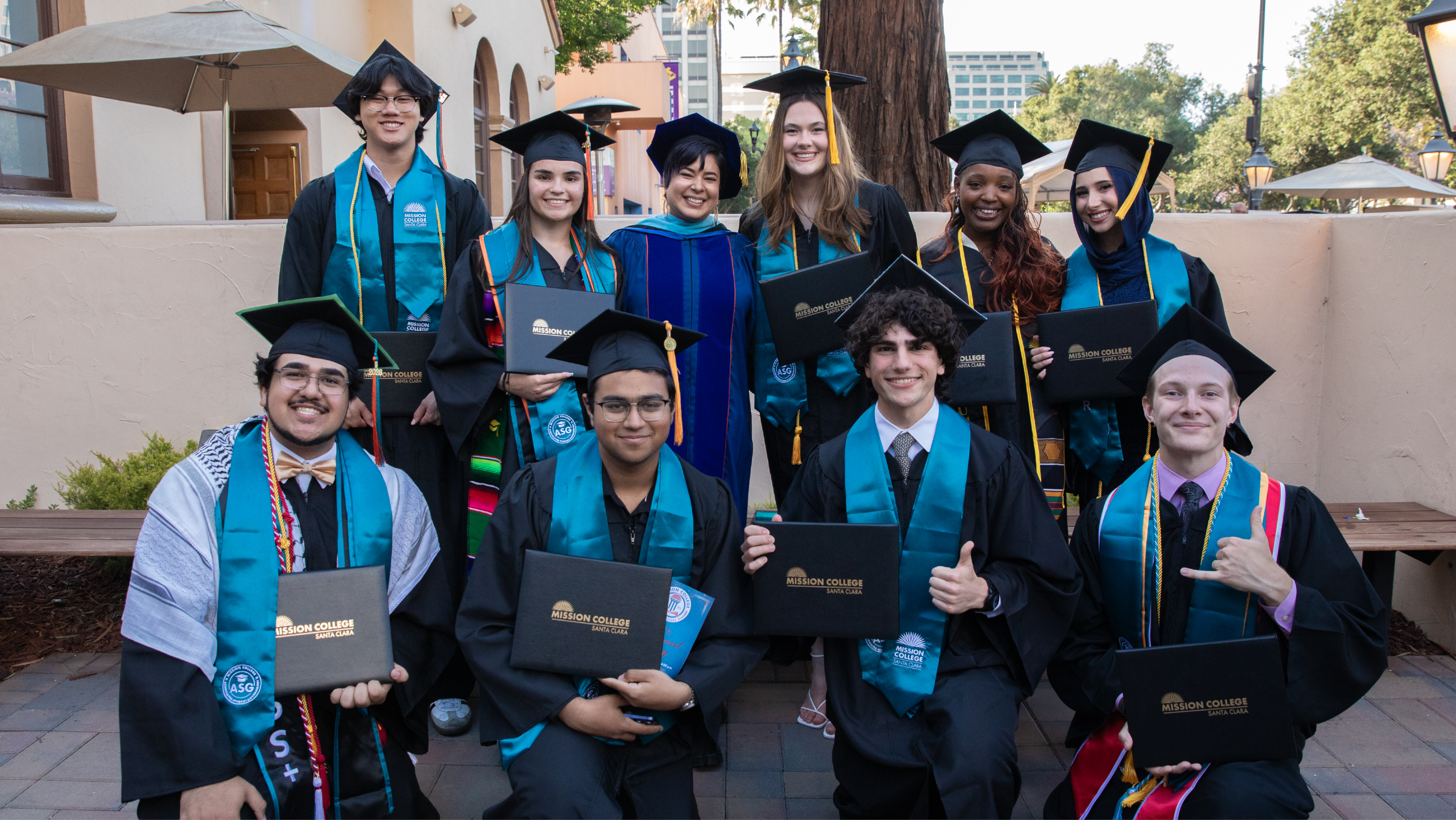 Mission College graduates posing outdoors with three family members.
