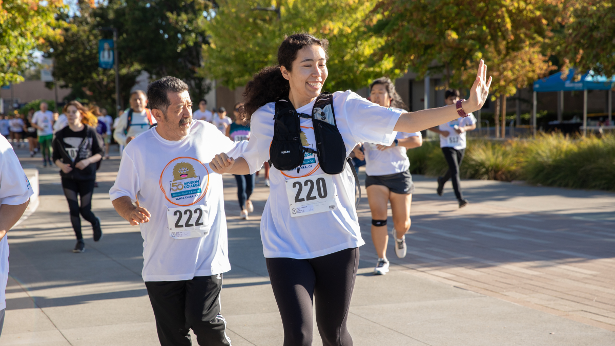 A participant waves to the camera while completing the Monster Dash & Bash 5K on the Mission College campus.