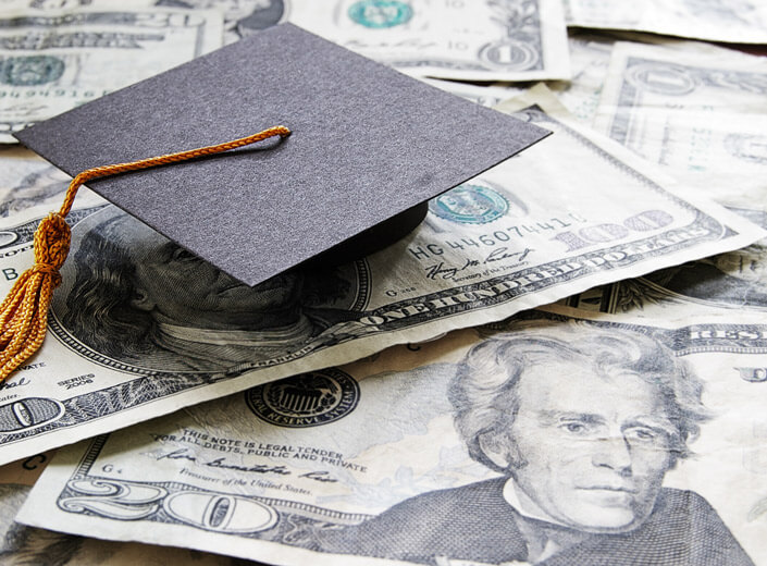 A commencement cap is placed on top of cash.