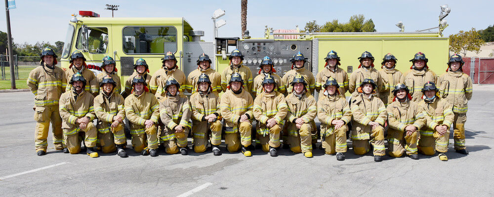 Group of Fire Academy 1 students pose in their uniforms in a group.
