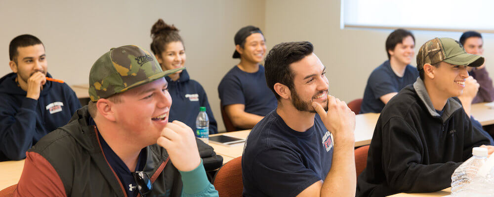 Group of engaged Fire Tech students pay attention to a lesson in a classroom.