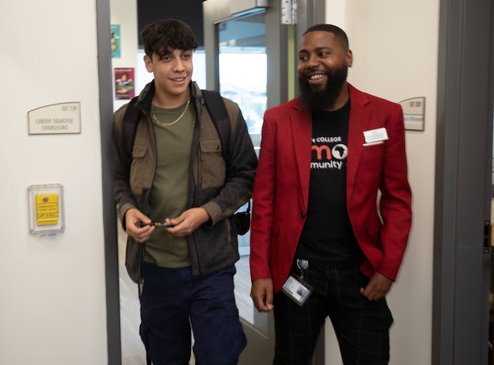 Roshawn, a Counselor walks with a young man as he assists him.