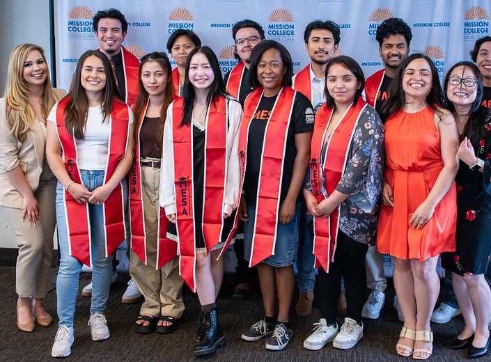 MESA graduates in red/orange sashes.