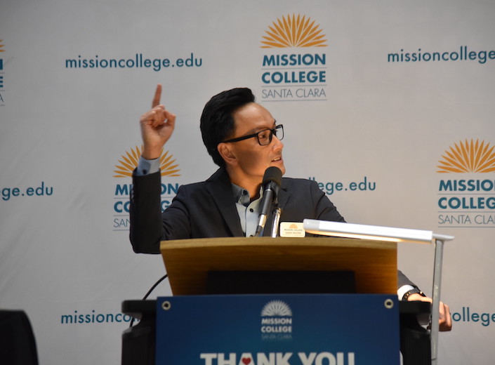 Danny Nguyen gestures at a podium during a campus event.