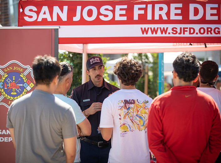 San Jose Fire Department booth is attended by several young men on a sunny day at the First Responder Fair at Mission College.
